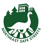 NESS logo: a loch nessie strolling across a crosswalk flanked by trees